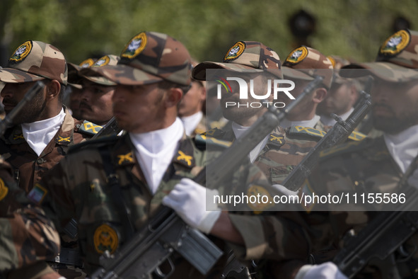 Members of the Iranian Army's land force are marching in a military parade to mark the anniversary of Iran's Army Day at an Army military ba...