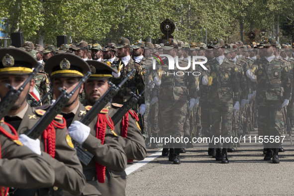 Members of the Iranian Army's land force are marching in a military parade to mark the anniversary of Iran's Army Day at an Army military ba...