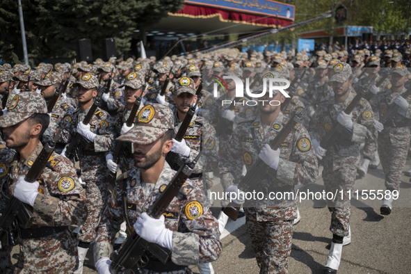 Members of the Iranian Army's land force are marching in a military parade to mark the anniversary of Iran's Army Day at an Army military ba...