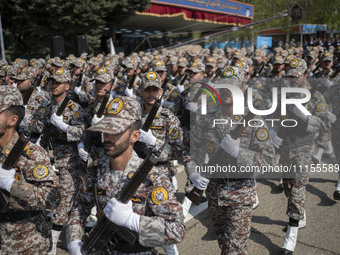 Members of the Iranian Army's land force are marching in a military parade to mark the anniversary of Iran's Army Day at an Army military ba...