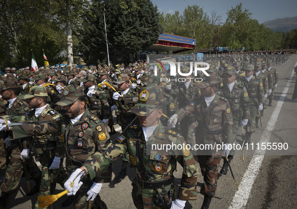 Members of the Iranian Army's land force are marching in a military parade to mark the anniversary of Iran's Army Day at an Army military ba...