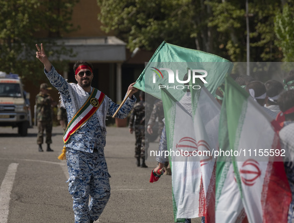 A member of the Basij paramilitary force is flashing a victory sign after marching in a military parade marking Iran's Army Day anniversary...