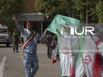 A member of the Basij paramilitary force is flashing a victory sign after marching in a military parade marking Iran's Army Day anniversary...