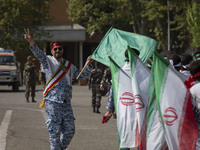 A member of the Basij paramilitary force is flashing a victory sign after marching in a military parade marking Iran's Army Day anniversary...