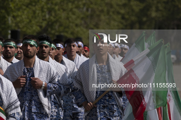 Members of the Basij paramilitary force are marching in a military parade to mark the anniversary of Iran's Army Day at an Army military bas...