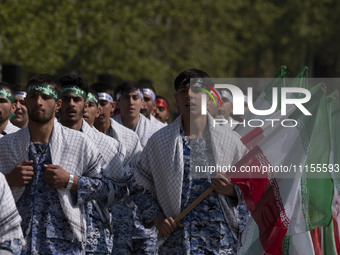 Members of the Basij paramilitary force are marching in a military parade to mark the anniversary of Iran's Army Day at an Army military bas...