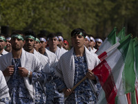 Members of the Basij paramilitary force are marching in a military parade to mark the anniversary of Iran's Army Day at an Army military bas...