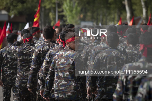 A member of the Basij paramilitary force is looking back while marching in a military parade to mark Iran's Army Day anniversary at an Army...