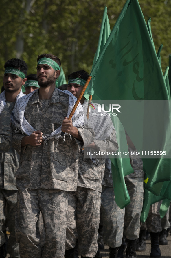 Members of the Basij paramilitary force are marching in a military parade to mark the anniversary of Iran's Army Day at an Army military bas...