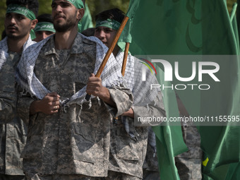 Members of the Basij paramilitary force are marching in a military parade to mark the anniversary of Iran's Army Day at an Army military bas...