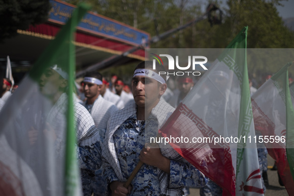 Members of the Basij paramilitary force are marching in a military parade to mark the anniversary of Iran's Army Day at an Army military bas...