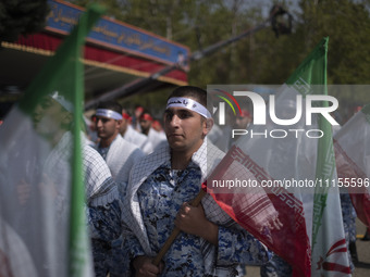 Members of the Basij paramilitary force are marching in a military parade to mark the anniversary of Iran's Army Day at an Army military bas...