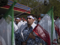 Members of the Basij paramilitary force are marching in a military parade to mark the anniversary of Iran's Army Day at an Army military bas...