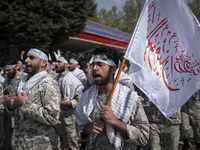 Members of the Basij paramilitary force are marching in a military parade to mark the anniversary of Iran's Army Day at an Army military bas...