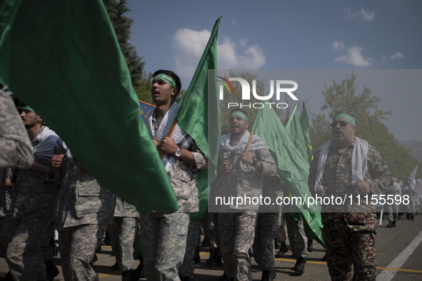 Members of the Basij paramilitary force are marching in a military parade to mark the anniversary of Iran's Army Day at an Army military bas...