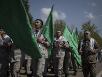 Members of the Basij paramilitary force are marching in a military parade to mark the anniversary of Iran's Army Day at an Army military bas...