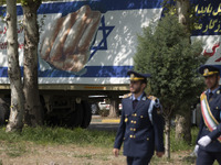 Two members of the Iranian Army's air force are walking past a massive anti-Israeli billboard after a military parade marking the anniversar...