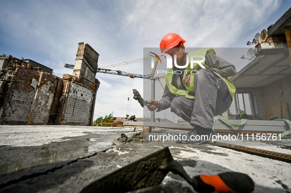 A worker is making mortar during the reconstruction of the residential building at 80 Nezalezhnoi Ukrainy Street/3 Yakova Novytskoho Street,...