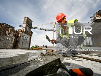 A worker is making mortar during the reconstruction of the residential building at 80 Nezalezhnoi Ukrainy Street/3 Yakova Novytskoho Street,...