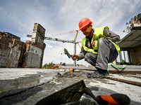 A worker is making mortar during the reconstruction of the residential building at 80 Nezalezhnoi Ukrainy Street/3 Yakova Novytskoho Street,...