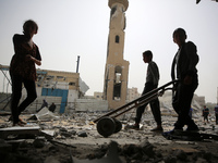 Palestinians are gathering around residential buildings that were destroyed during an Israeli raid, amid the ongoing conflict between Israel...