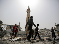 Palestinians are gathering around residential buildings that were destroyed during an Israeli raid, amid the ongoing conflict between Israel...