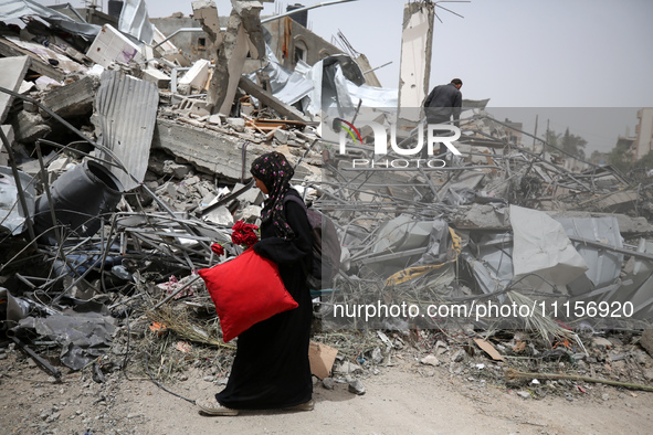 Palestinians are gathering around residential buildings that were destroyed during an Israeli raid, amid the ongoing conflict between Israel...