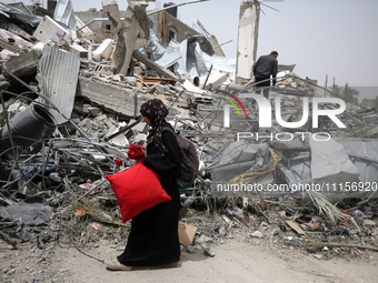 Palestinians are gathering around residential buildings that were destroyed during an Israeli raid, amid the ongoing conflict between Israel...