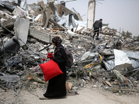 Palestinians are gathering around residential buildings that were destroyed during an Israeli raid, amid the ongoing conflict between Israel...