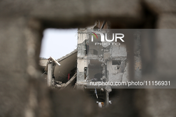 Palestinians are gathering around residential buildings that were destroyed during an Israeli raid, amid the ongoing conflict between Israel...