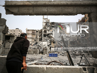 Palestinians are gathering around residential buildings that were destroyed during an Israeli raid, amid the ongoing conflict between Israel...