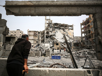 Palestinians are gathering around residential buildings that were destroyed during an Israeli raid, amid the ongoing conflict between Israel...