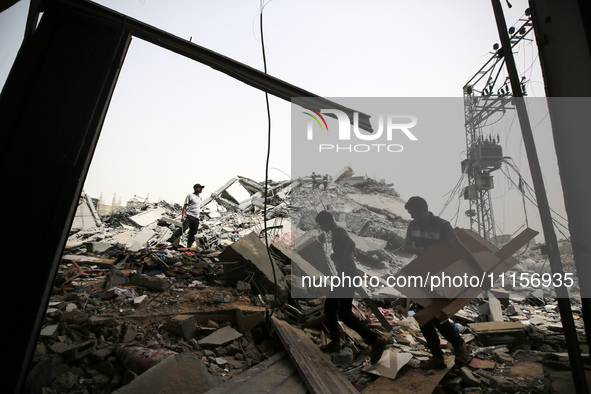 Palestinians are gathering around residential buildings that were destroyed during an Israeli raid, amid the ongoing conflict between Israel...