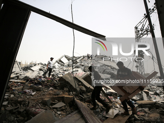 Palestinians are gathering around residential buildings that were destroyed during an Israeli raid, amid the ongoing conflict between Israel...