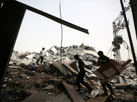 Palestinians are gathering around residential buildings that were destroyed during an Israeli raid, amid the ongoing conflict between Israel...