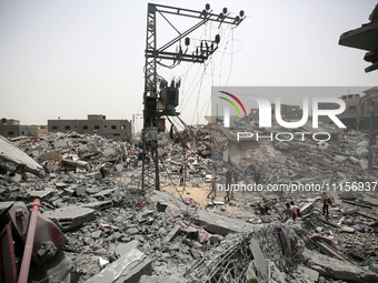 Palestinians are gathering around residential buildings that were destroyed during an Israeli raid, amid the ongoing conflict between Israel...