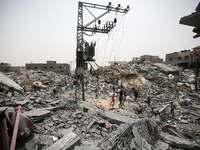 Palestinians are gathering around residential buildings that were destroyed during an Israeli raid, amid the ongoing conflict between Israel...