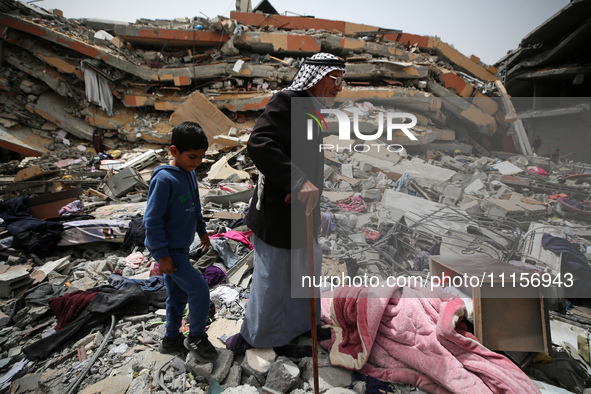 Palestinians are gathering around residential buildings that were destroyed during an Israeli raid, amid the ongoing conflict between Israel...