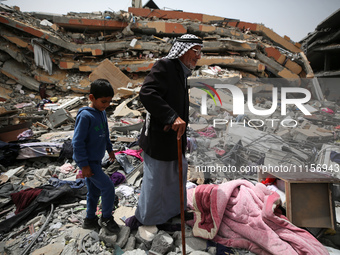 Palestinians are gathering around residential buildings that were destroyed during an Israeli raid, amid the ongoing conflict between Israel...