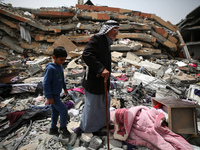 Palestinians are gathering around residential buildings that were destroyed during an Israeli raid, amid the ongoing conflict between Israel...