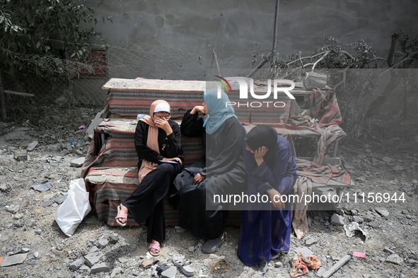 Palestinians are gathering around residential buildings that were destroyed during an Israeli raid, amid the ongoing conflict between Israel...