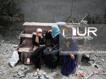 Palestinians are gathering around residential buildings that were destroyed during an Israeli raid, amid the ongoing conflict between Israel...