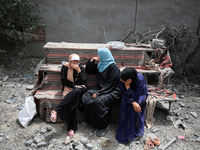 Palestinians are gathering around residential buildings that were destroyed during an Israeli raid, amid the ongoing conflict between Israel...