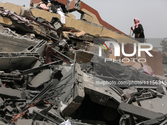 Palestinians are gathering around residential buildings that were destroyed during an Israeli raid, amid the ongoing conflict between Israel...