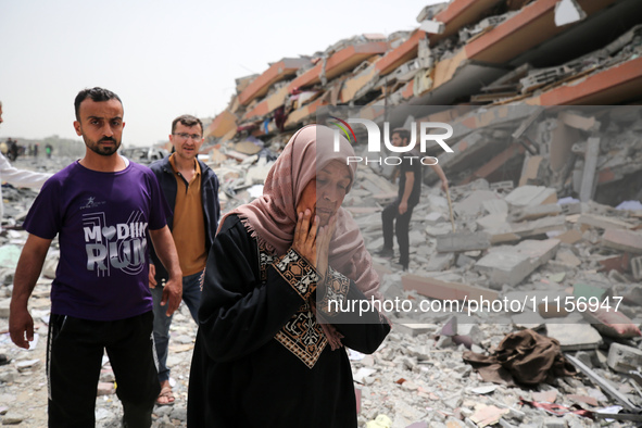 Palestinians are gathering around residential buildings that were destroyed during an Israeli raid, amid the ongoing conflict between Israel...