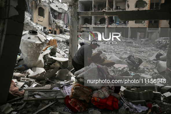 Palestinians are gathering around residential buildings that were destroyed during an Israeli raid, amid the ongoing conflict between Israel...