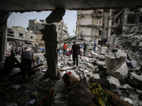 Palestinians are gathering around residential buildings that were destroyed during an Israeli raid, amid the ongoing conflict between Israel...