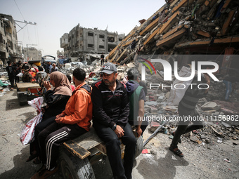 Palestinians are gathering around residential buildings that were destroyed during an Israeli raid, amid the ongoing conflict between Israel...