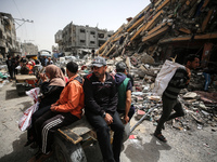 Palestinians are gathering around residential buildings that were destroyed during an Israeli raid, amid the ongoing conflict between Israel...