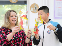 A foreign friend from South Africa is experiencing Chinese shadow play with a primary school child in Qingdao, Shandong Province, China, on...